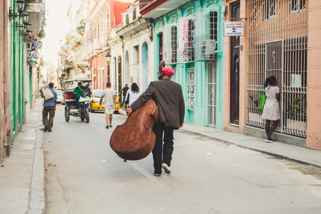 man wondering the streets carrying an instrument 