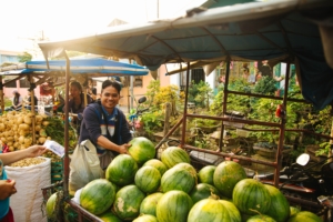 man selling water melons in the market in the philippines