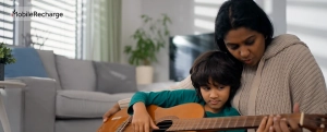 indian mom teaching her kid to play guitar